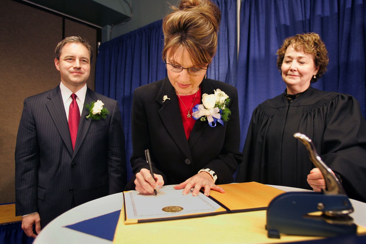 Palin signs her oath of office document as Lt. Gov. Sean Parnell, left, and Superior Court Judge Niesje Steinkruger look on after her swearing-in ceremony in Fairbanks, Alaska, in December 2006.