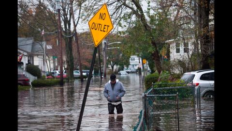 A man walks through a flooded street on October 30, 2012, in Little Ferry, New Jersey. 
