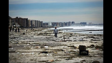  A man walks along the heavily damaged Rockaway beach on November 2, 2012. 