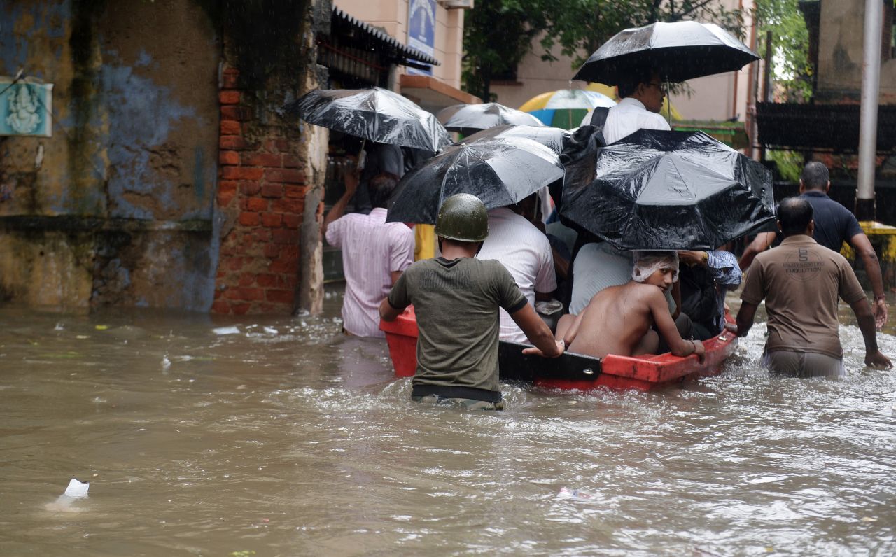 Indian police officials pull a boat through water-logged streets as they ferry residents to a safer place in Kolkata on October 26.