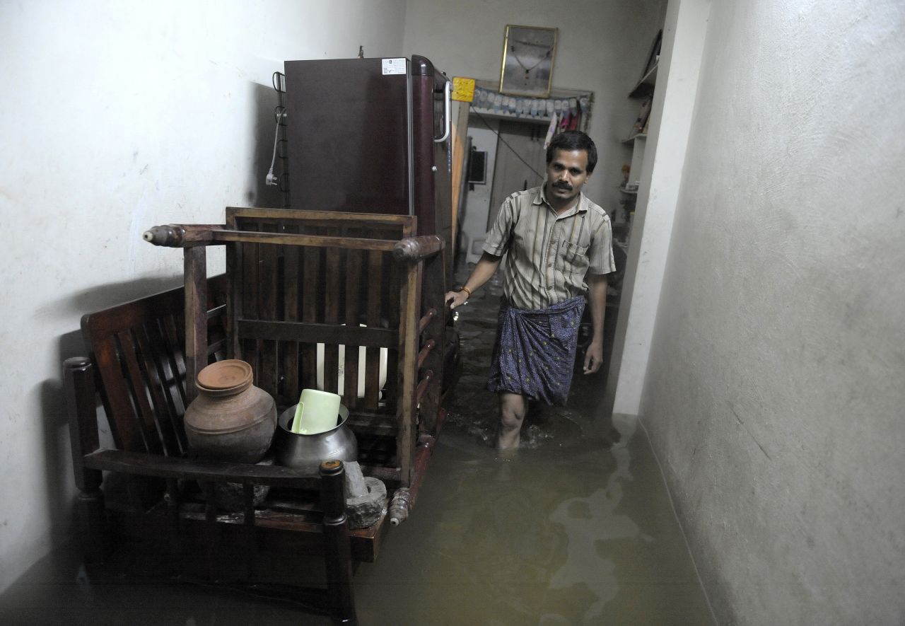 A resident walks through a flooded house following heavy rain in Saroornagar, a low lying area on the outskirts of Hyderabad on October 25.