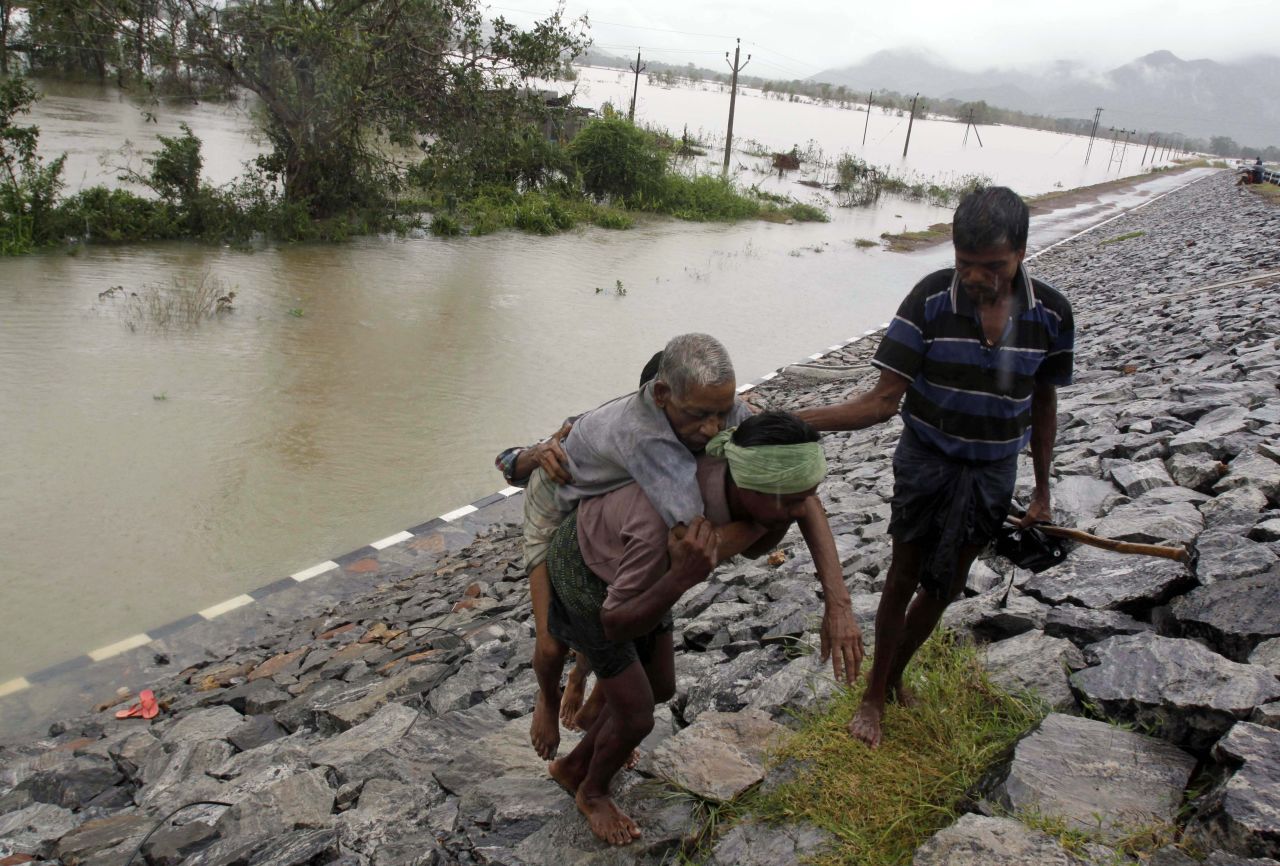 A villager carries an elderly man to safety after crossing floodwaters in Khurda district in the eastern Indian state of Orissa on Friday, October 25.