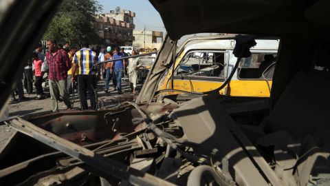 Citizens are seen through a broken window of a bus destroyed in a blast at a bus station in Baghdad Sunday.