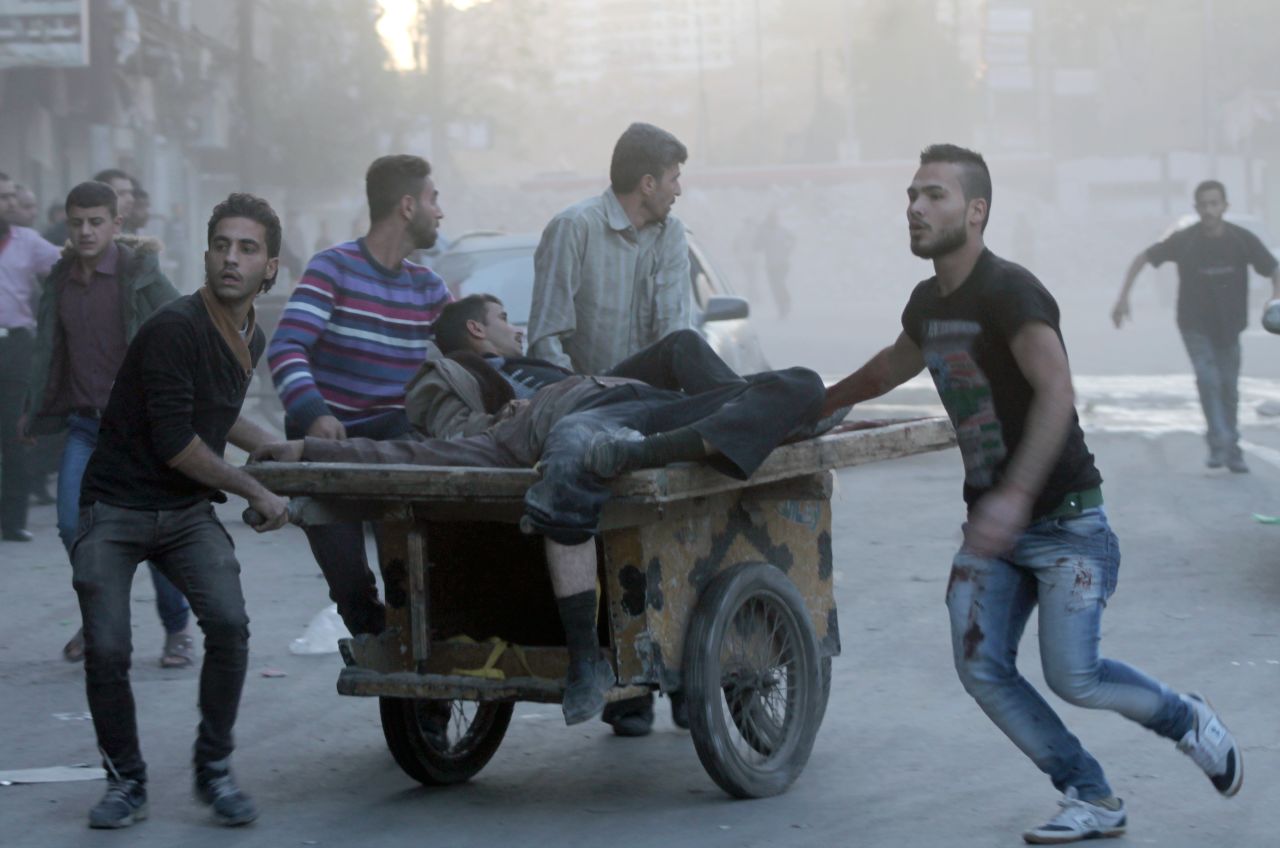 Two injured men are transported on a cart in  Aleppo, Syria, following shelling as fighting between pro-government forces and rebels continues on Saturday, October 26. 