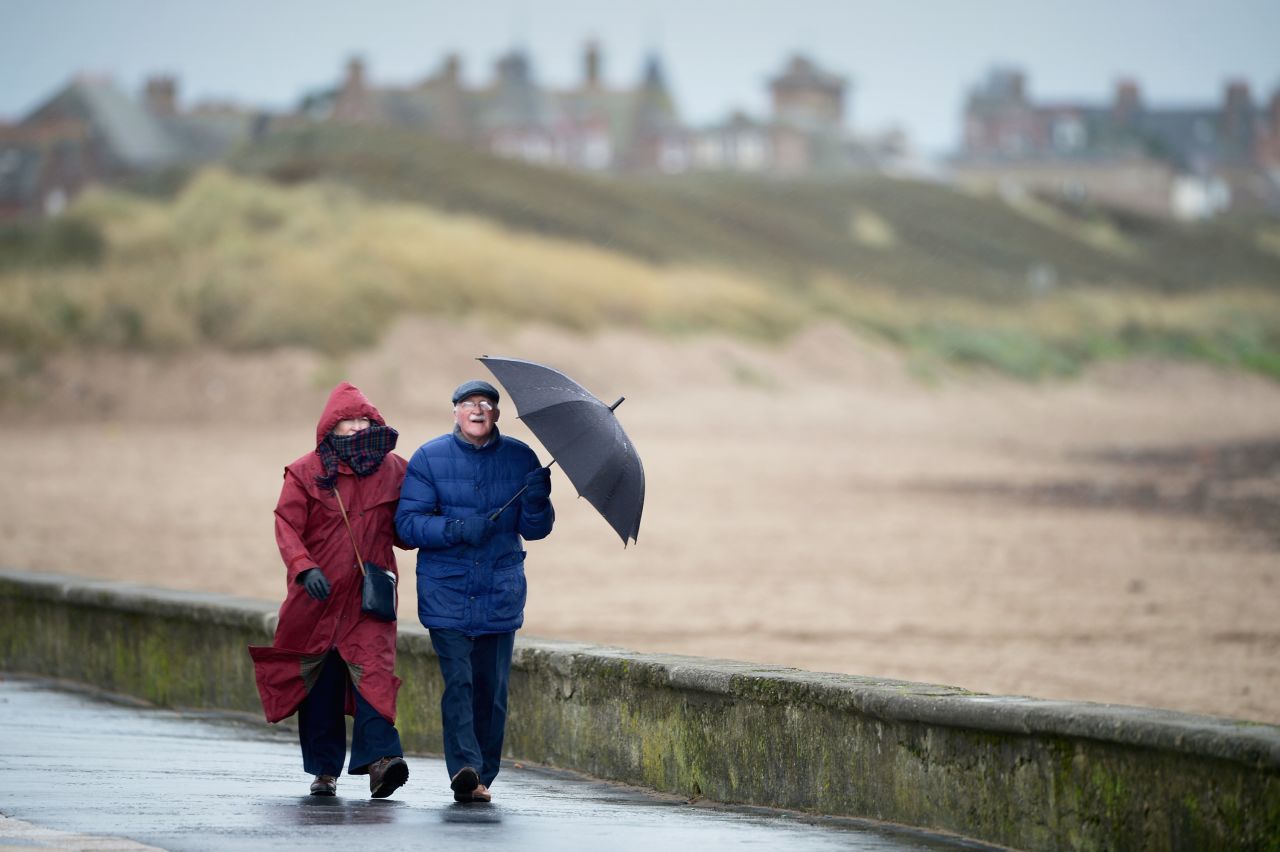 People walk along the Troon South beach in Troon, Scotland, on Monday.
