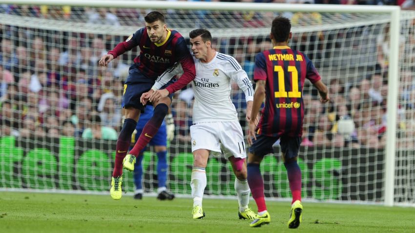 Real Madrid's Welsh striker Gareth Bale (C) vies with Barcelona's defender Gerard Pique during the Spanish league Clasico football match FC Barcelona vs Real Madrid CF at the Camp Nou stadium in Barcelona on October 26, 2013. AFP PHOTO / JOSEP LAGOJOSEP LAGO/AFP/Getty Images
