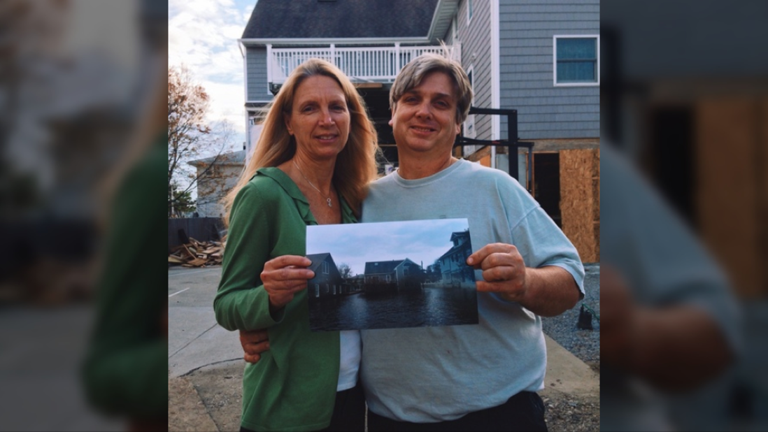 Darren and Anne Erbe stand in front of their new home, holding a photo of their old house in Bay Head, New Jersey, which was taken after Hurricane Sandy hit on Oct. 29, 2012. They had to move four times in the past year.