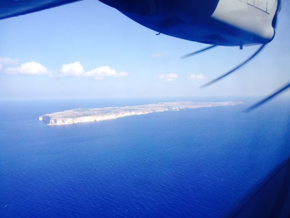 The view out of a window on the Frontex surveillance plane shows the Italian island of Lampedusa. More than 300 migrants died in a shipwreck while attempting to reach the island in early October.