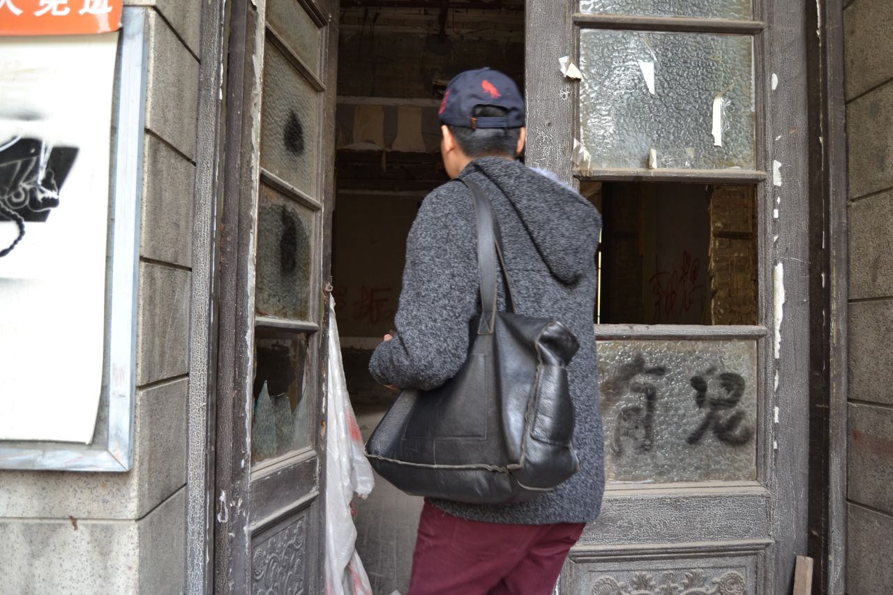 This brave visitor entering the famed Chaoyangmen Inner Street building chooses to ignore the sign warning "there are ghosts" on the window to his right. 