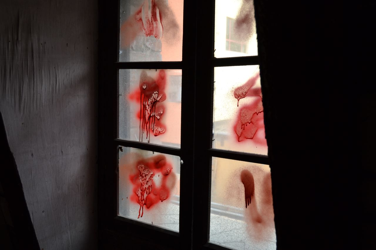 Seems someone felt the building wasn't spooky enough. Red spray paint adds unconvincing blood stains to the window.  