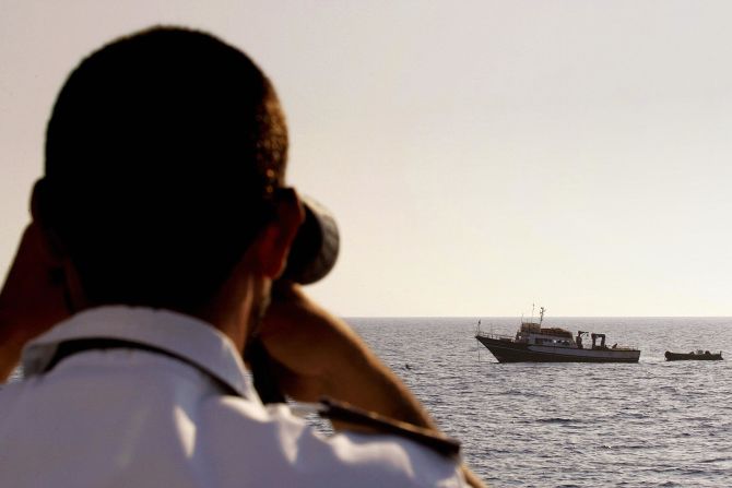 An Italian coast guard officer checks a Tunisian fishing boat in the Mediterranean.
