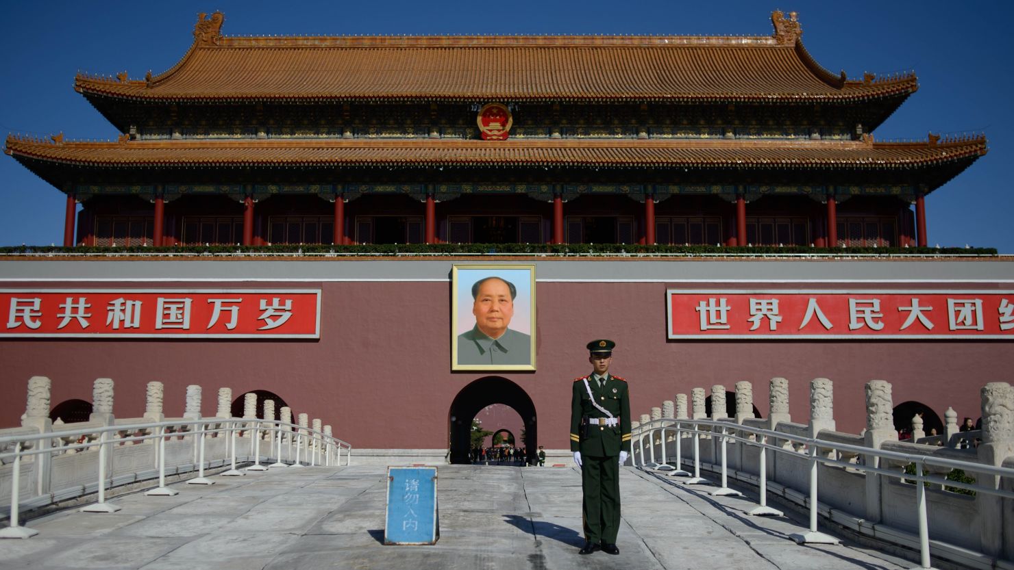 A paramilitary policeman stands before a portrait of Mao Zedong at Tiananmen Gate  in Beijing.