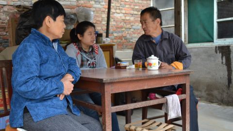 Li Xue sits with her parents at their Beijing home.