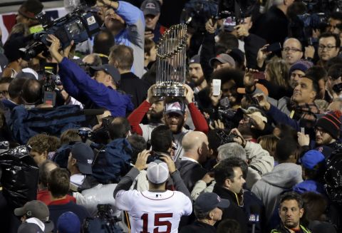 Boston Red Sox players hold up the championship trophy after Game 6 of baseball's World Series against the St. Louis Cardinals on Wednesday, October 30, in Boston. The Red Sox defeated the Cardinals 6-1. 