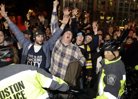 Fans are ushered along a street by law enforcement officials. 