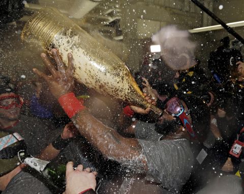Boston Red Sox's David Ortiz drinks out of a giant bottle of Champagne as he celebrates with teammates. Ortiz was named the series MVP.