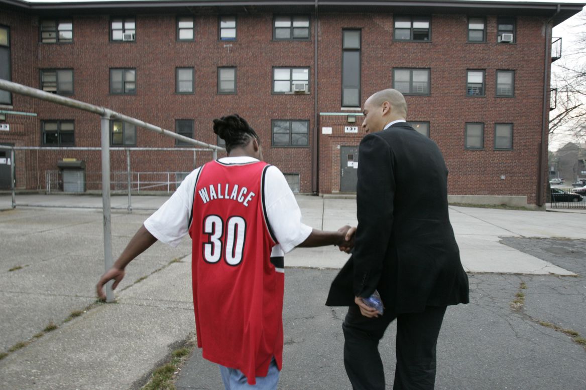 Booker greets a Newark resident at a public housing complex while campaigning for mayoral votes in March 2006.