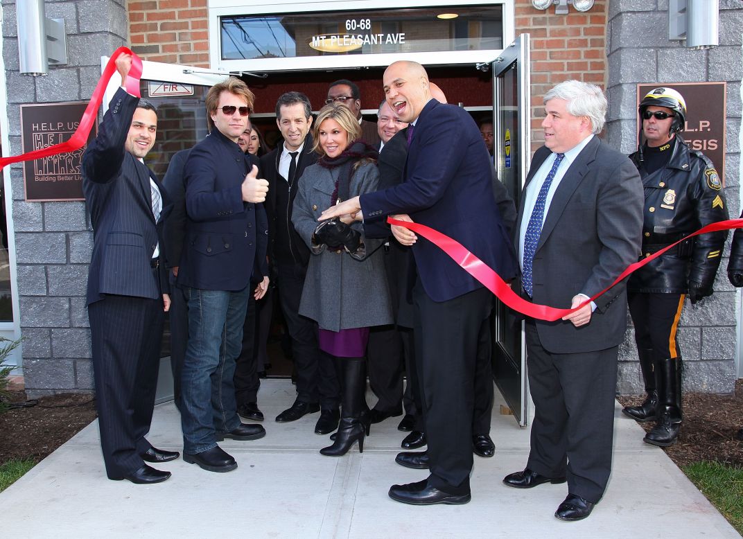 Booker helps cut the ribbon at the opening of affordable housing in Newark in December 2009. The housing was funded through Jon Bon Jovi's JBJ Soul Foundation. The musician is second from left.