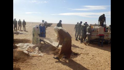 Men cover the bodies of the migrants. Ninety-two bodies have been found, Niger security forces said Thursday. Most of the victims were women and children. 