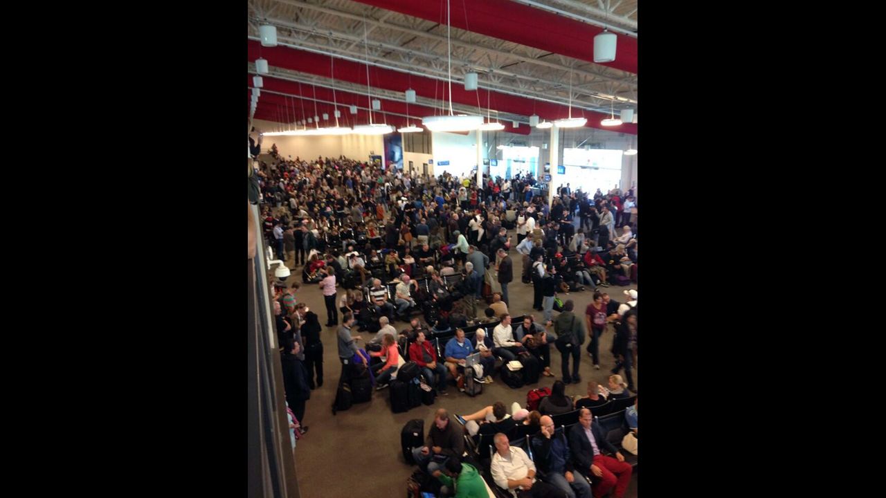 People wait in a terminal after flights were grounded because of the incident.