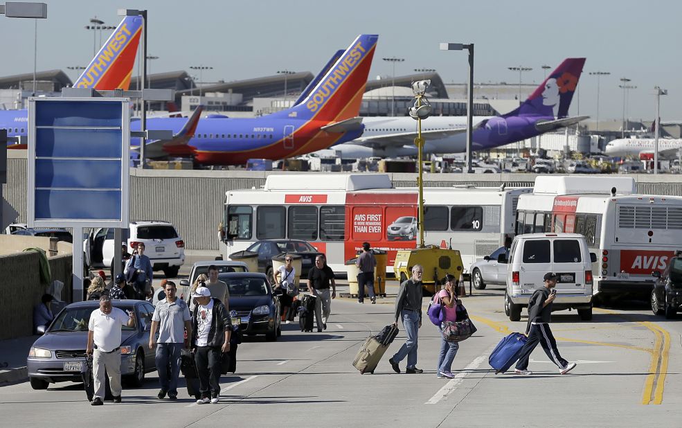 Passengers evacuate the airport after the incident, which airport officials said began about 9:30 a.m. The gunfire and the airport's announcement of the incident provoked chaos among travelers, passengers said.