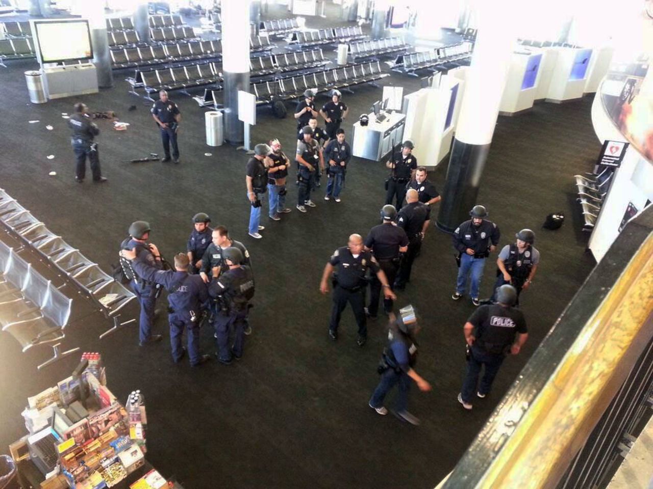 Law enforcement officers gather in Terminal 3 near the scene of the shooting.