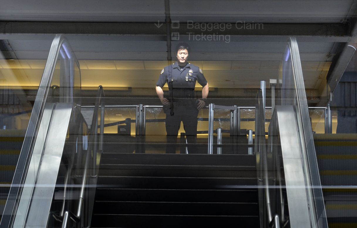 A Los Angeles Airport Police officer stands in front of Terminal 3 security screeners after law enforcement officials completed their investigation and prepare to reopen the terminal at LAX on November 2.