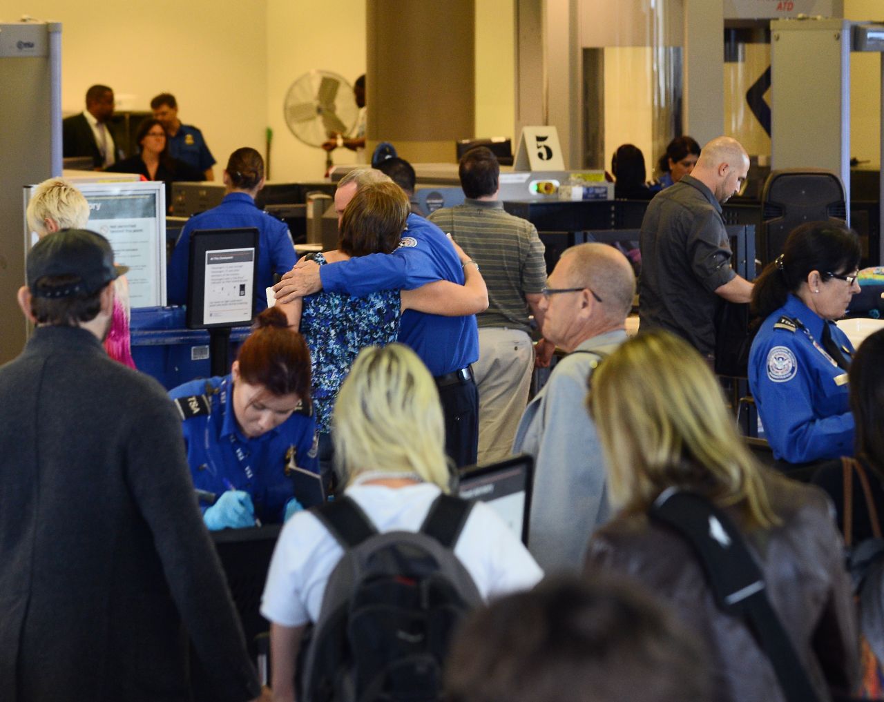A passenger embraces a TSA screener at Los Angeles International Airport's Terminal 3 after it was reopened on Saturday, November 2 following a shooting.  Four other people are recovering from injuries in the shooting.