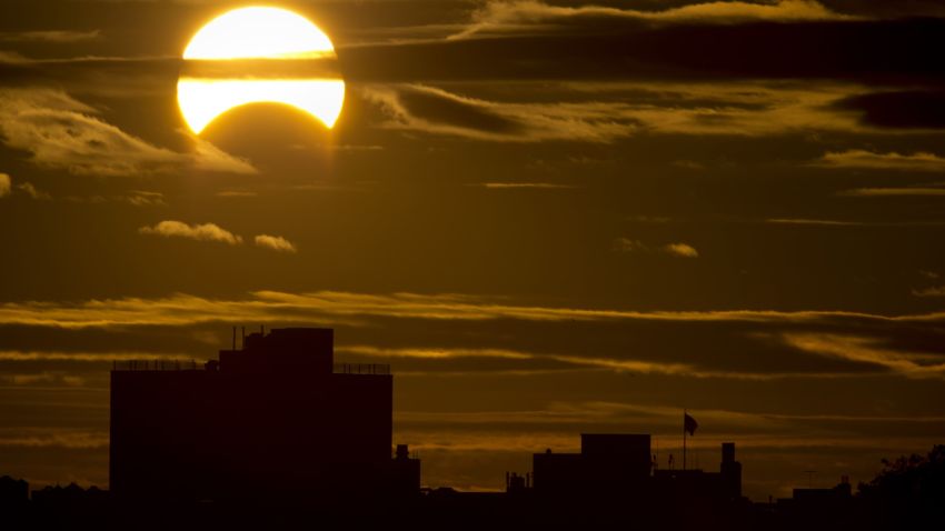 A partial Solar eclipse is seen just after sunrise over the Queens borough of New York across the East River on November 3, 2013 in New York.    AFP PHOTO/Stan HONDA        (Photo credit should read STAN HONDA/AFP/Getty Images)