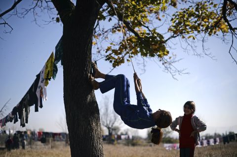 A Syrian refugee uses a rope to climb a tree at the Vrazhdebna shelter on Tuesday, October 29.
