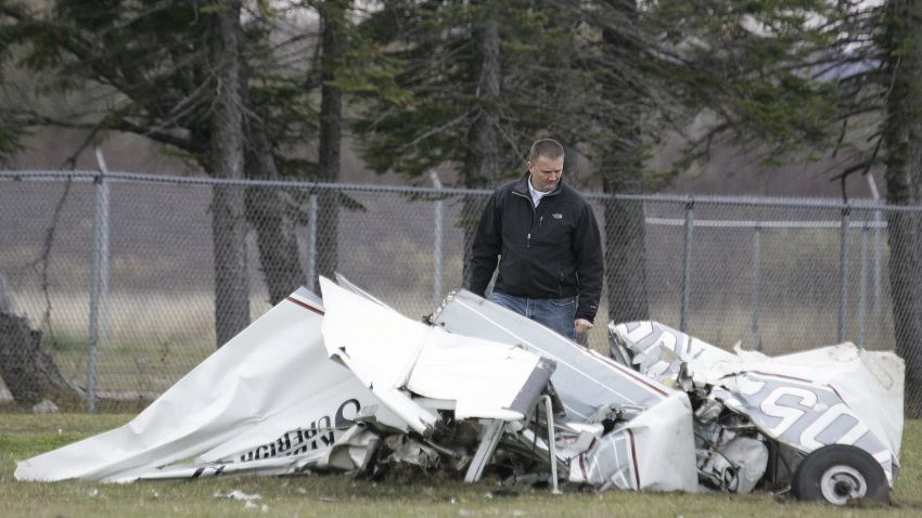 An FAA investigator Sunday, Nov. 3, 2013 examines the wreckage of a plane that crashed in Superior, Wis., Saturday after a midair collision with another plane. Both planes were carrying skydivers. No one was seriously injured in the incident.