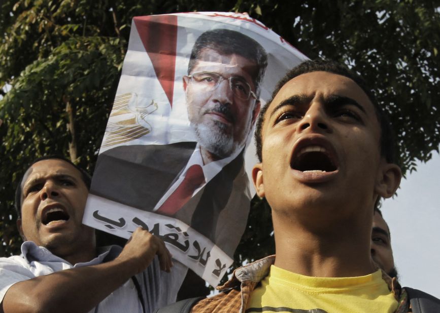 Morsy supporters raise a poster that reads "no to the coup" in Arabic.