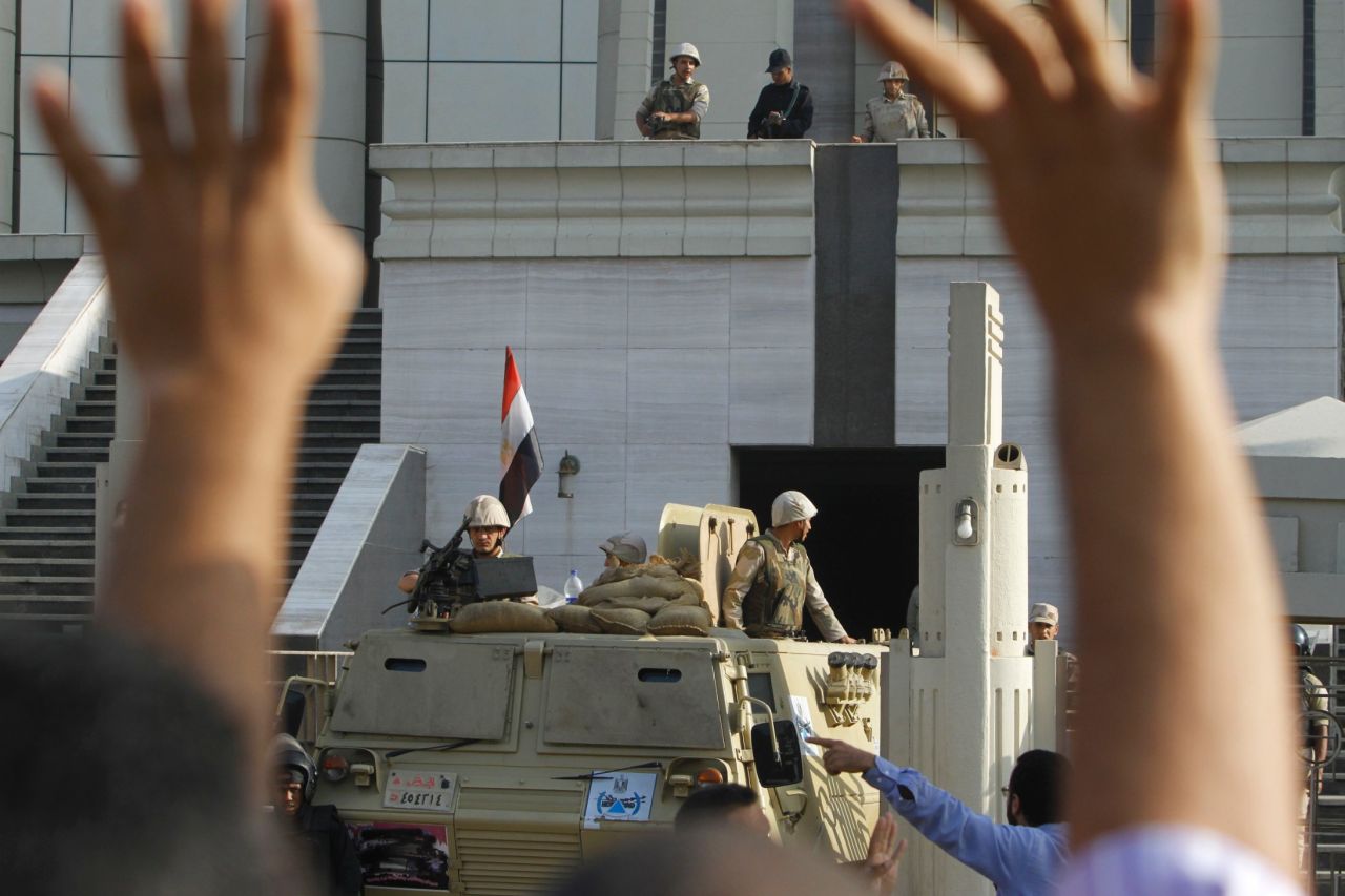 A Morsy supporter raises his hands in front of army soldiers guarding the Supreme Constitutional Court.