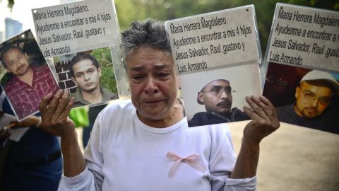 A woman shows pictures of relatives missing in  Mexico's drug war at a rally of mothers whose children have disappeared.
