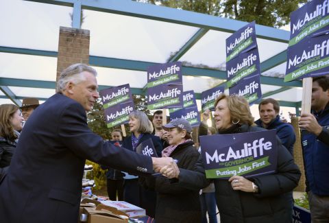 McAuliffe shakes hands with supporters after voting.