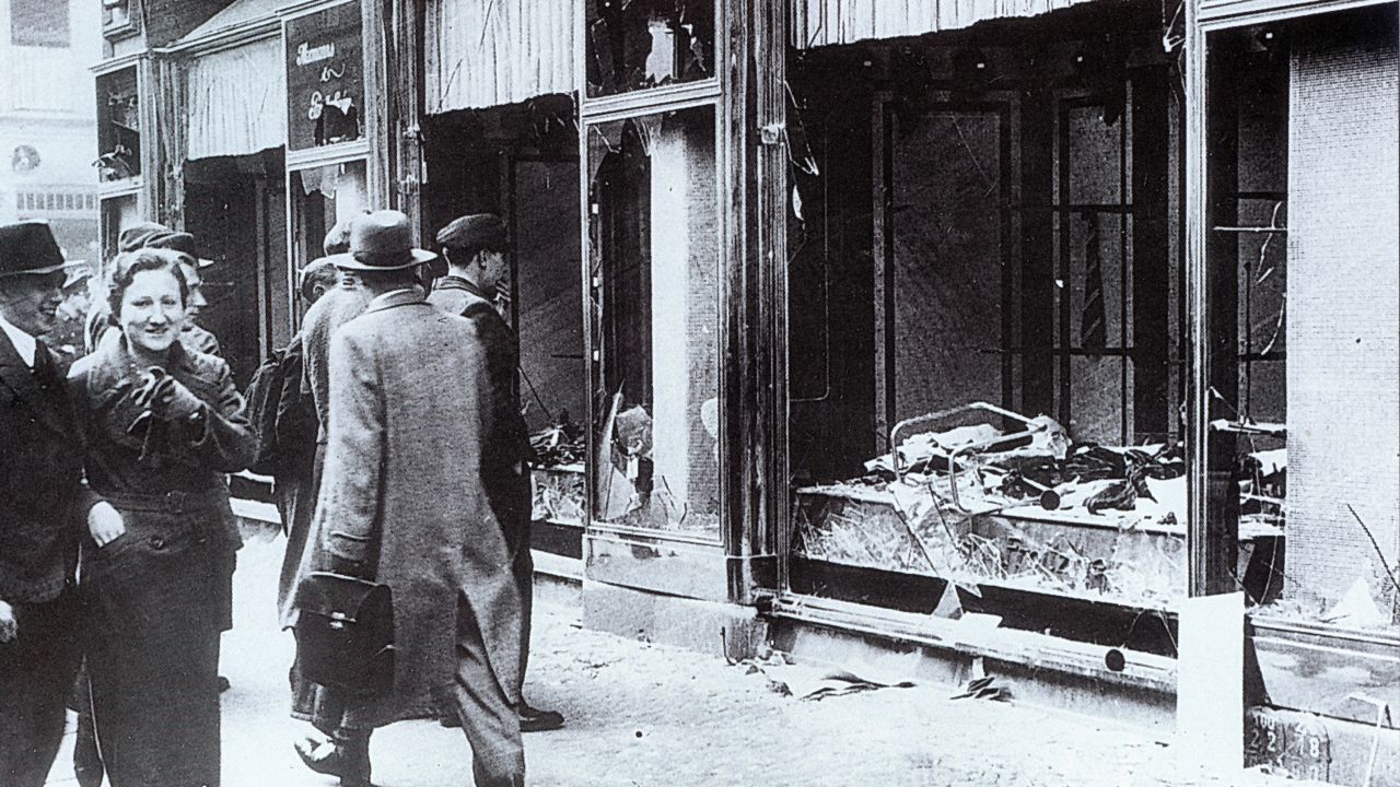 People walk past the broken windows of a Jewish-owned shop in Berlin. Over the course of two days, 91 Jewish people were killed and more than 1,000 synagogues and 7,500 businesses were destroyed.