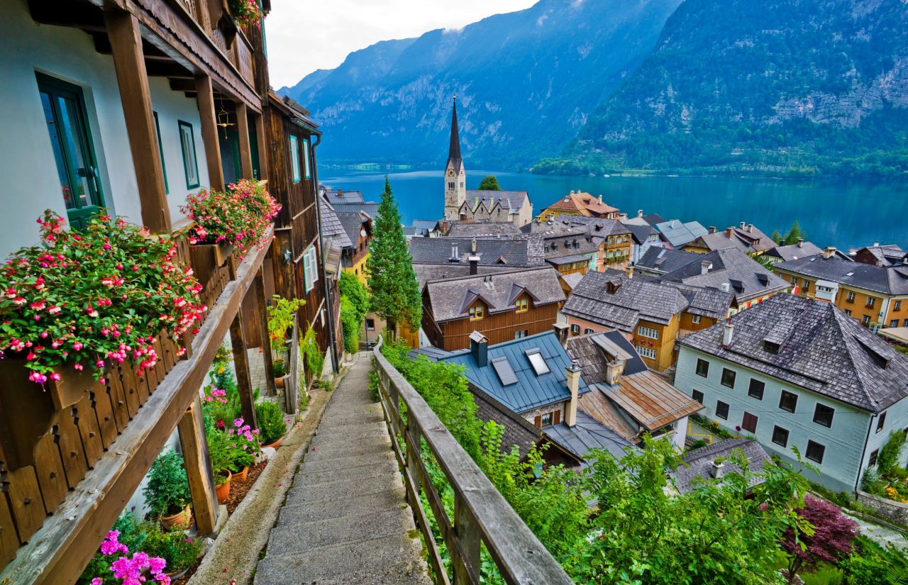 The idyllic town of Hallstatt is located between a pristine lake and a lush mountain rising from the water's edge. 