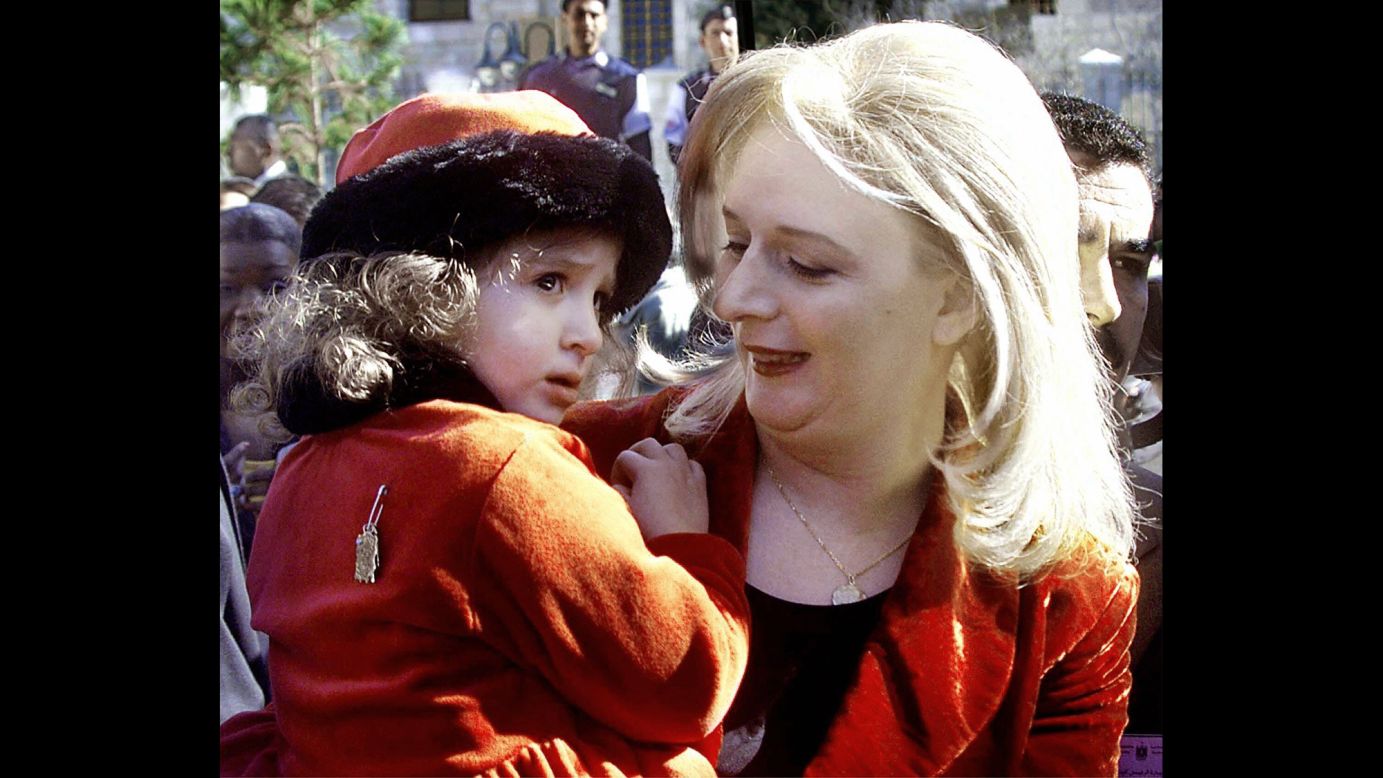 La esposa de Arafat, Suha, carga a su hija, Zahwa, en la ciudad cisjordana de Belén el 15 de diciembre de 1998.