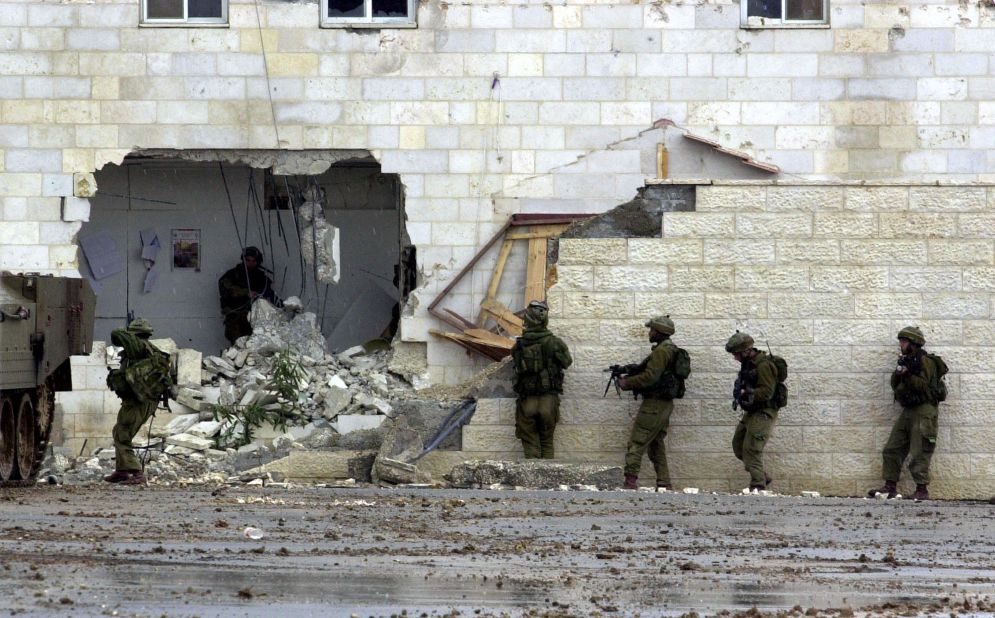 Israeli soldiers enter Arafat's West Bank headquarters in Ramallah on March 29, 2002. Tanks surrounded Arafat's compound earlier in the day in retaliation for a wave of recent suicide bombings. It was the beginning of a month-long siege.