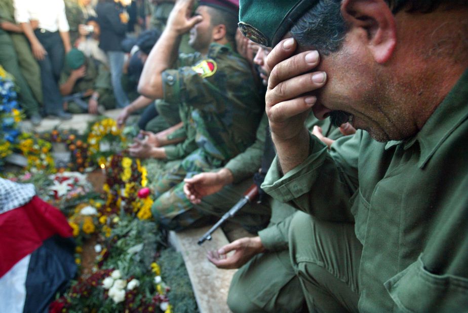 Palestinian security forces cry over Arafat's grave after he was buried at his compound in Ramallah on November 12, 2004.