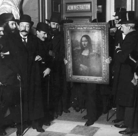 Officials crowd around the Mona Lisa upon her return to the Louvre in January 1914. Why such a fuss? She'd been missing for over two years.