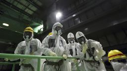 Members of the media wearing protective suits and masks look at the spent fuel pool from a fuel handling machine inside the building housing the Unit 4 reactor at the Fukushima Dai-ichi nuclear power plant in Okuma, Fukushima Prefecture, Japan, Thursday, Nov. 7, 2013.