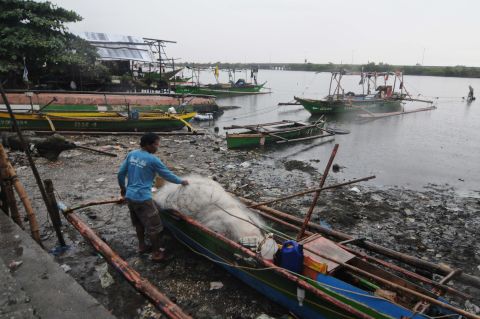 A resident unloads nets off a fishing boat in Bacoor on November 8.