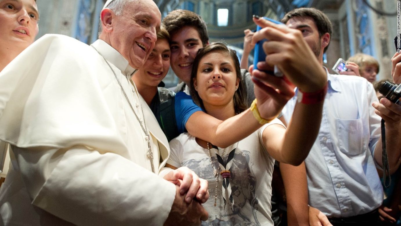 Francisco y jóvenes italianos tomándose la que probablemente es la primera foto 'selfie' del papa en agosto.
