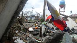 A man searches for salvageable materials among debris of his destroyed house near Tacloban Airport, eastern island of Leyte on November 9, 2013. More than 100 bodies were lying in the streets of a Philippine city smashed by Super Typhoon Haiyan, authorities said, as soldiers raced to reach many other devastated communities.
