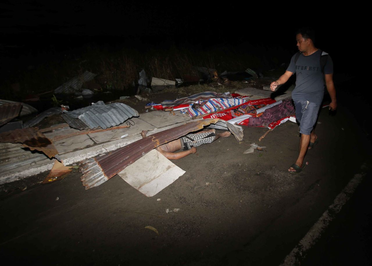 A resident passes victims' bodies on a Tacloban street November 9.