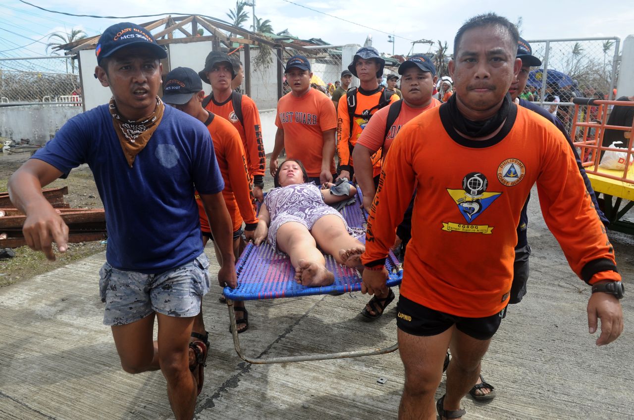 Rescue workers carry a woman about to give birth November 9 at a makeshift medical center at the Tacloban airport.