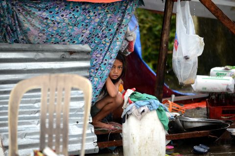 A girl peeks out from a makeshift shelter in Tacloban.