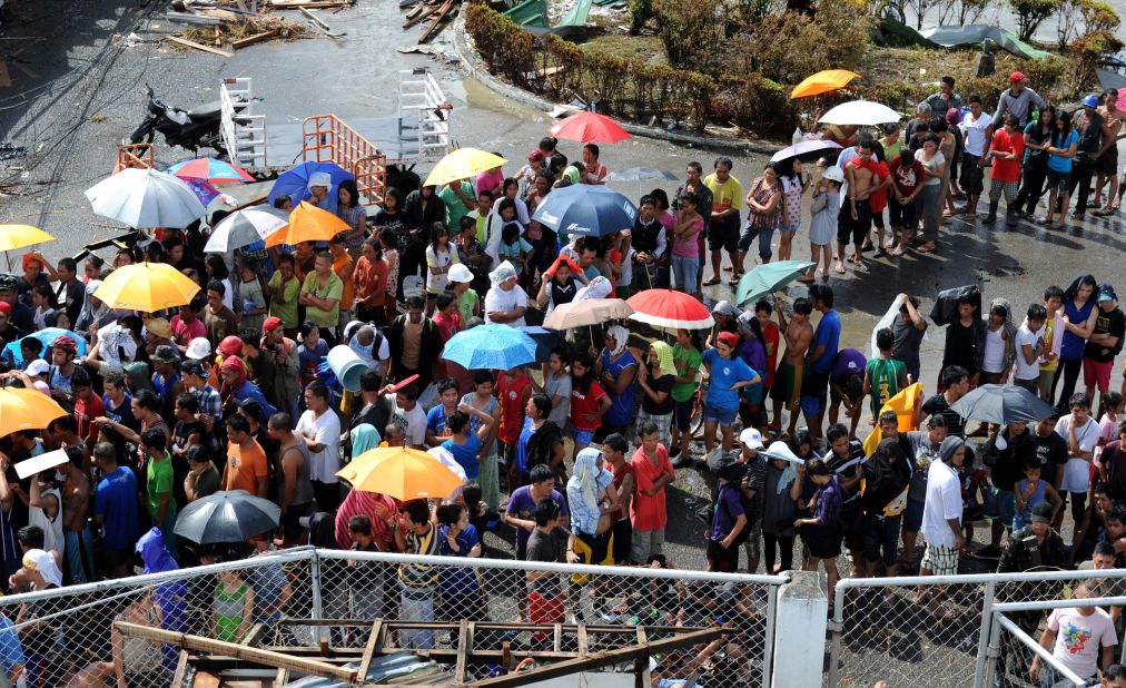 Typhoon survivors wait to receive relief goods at the Tacloban airport on November 10.