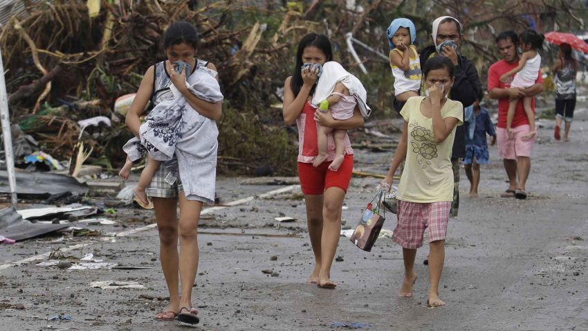 People cover their noses from the smell of dead bodies in Tacloban.